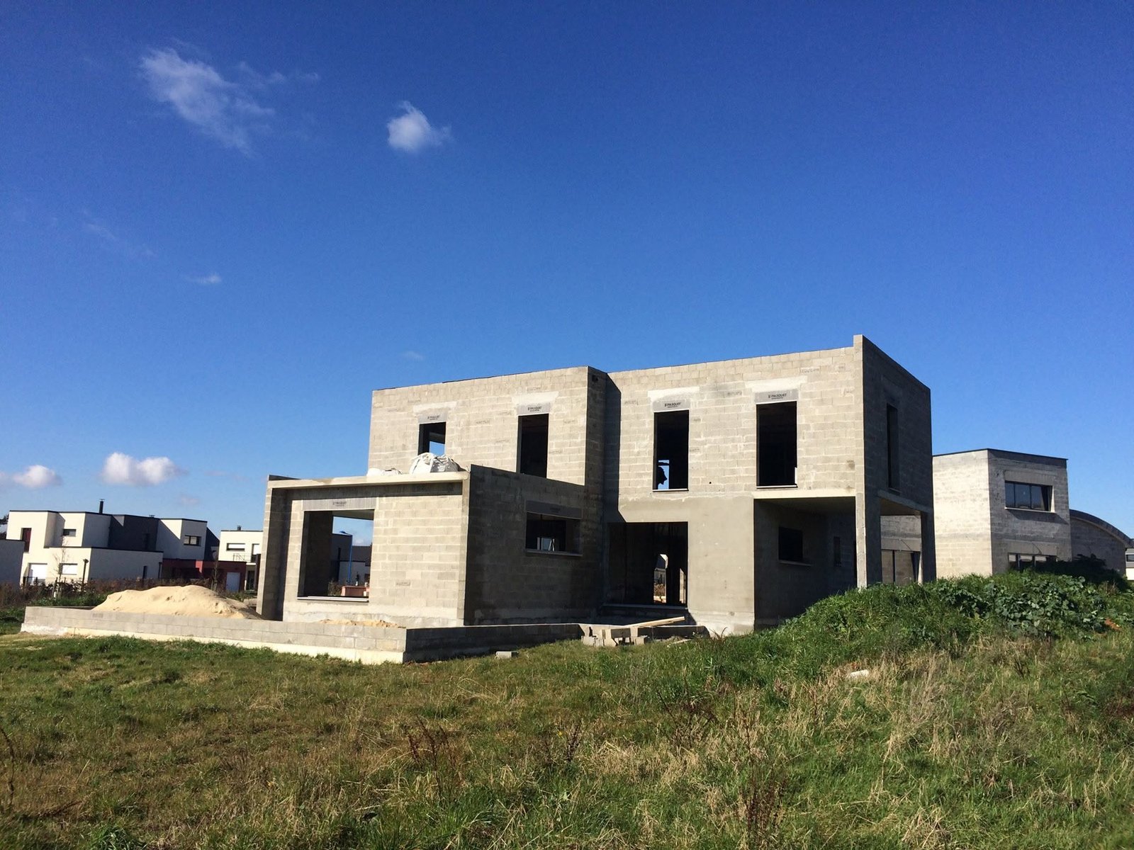 Maison contemporaine en cours de construction, structure en blocs béton et linteaux apparents